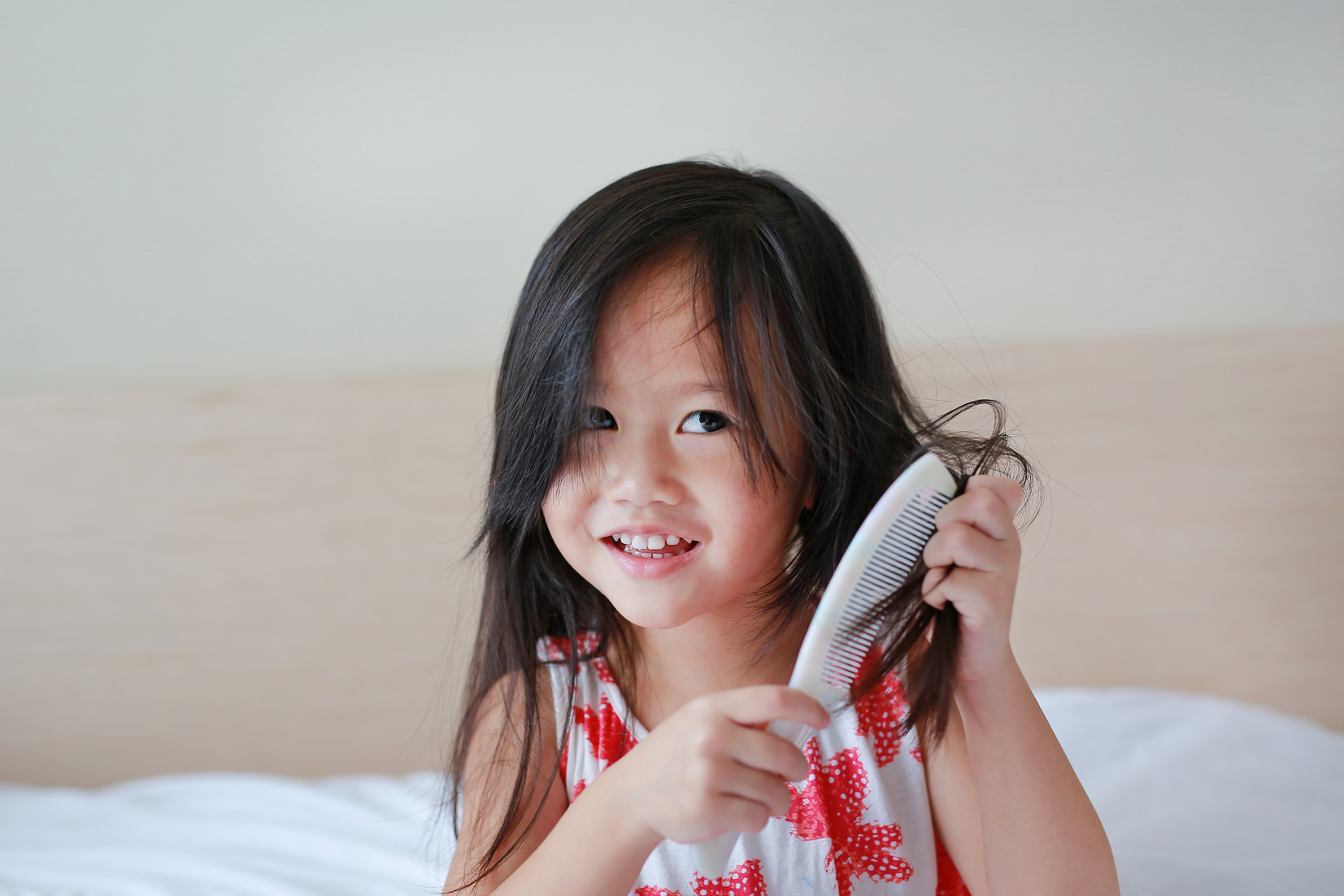 Asian child girl combing her hair.